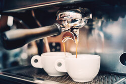 Een espressoapparaat waaronder twee kopjes koffie worden gezet